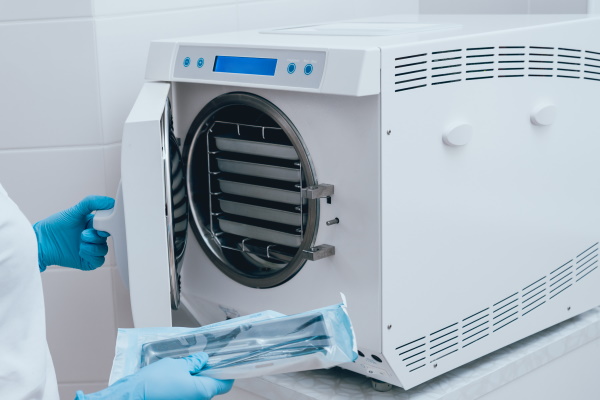 Sterilizing medical instruments in autoclave. Dental office